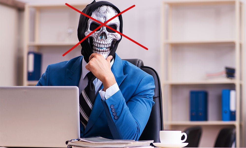 A person in a suit wearing a scary mask